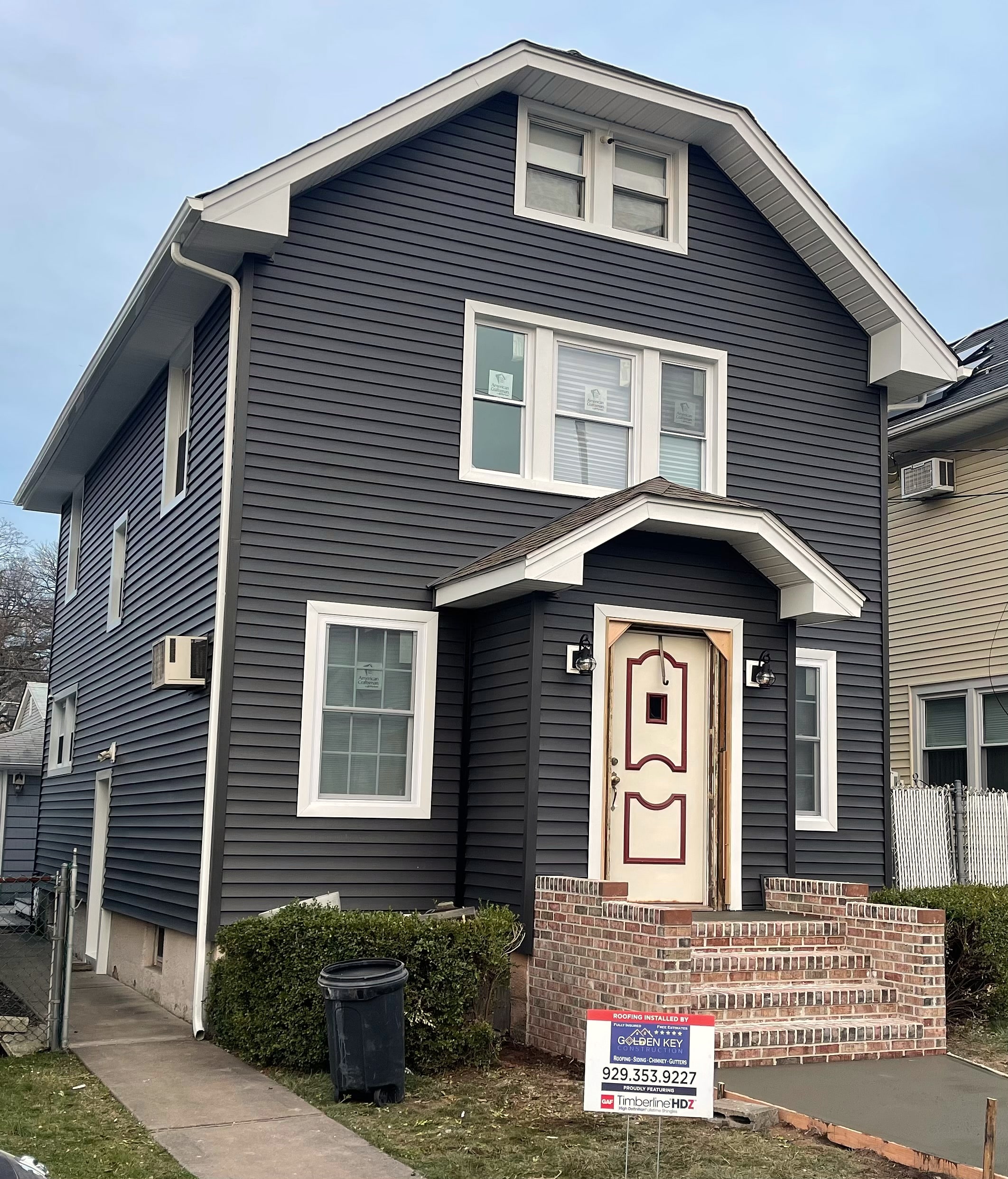 House with new gray siding and yard sign