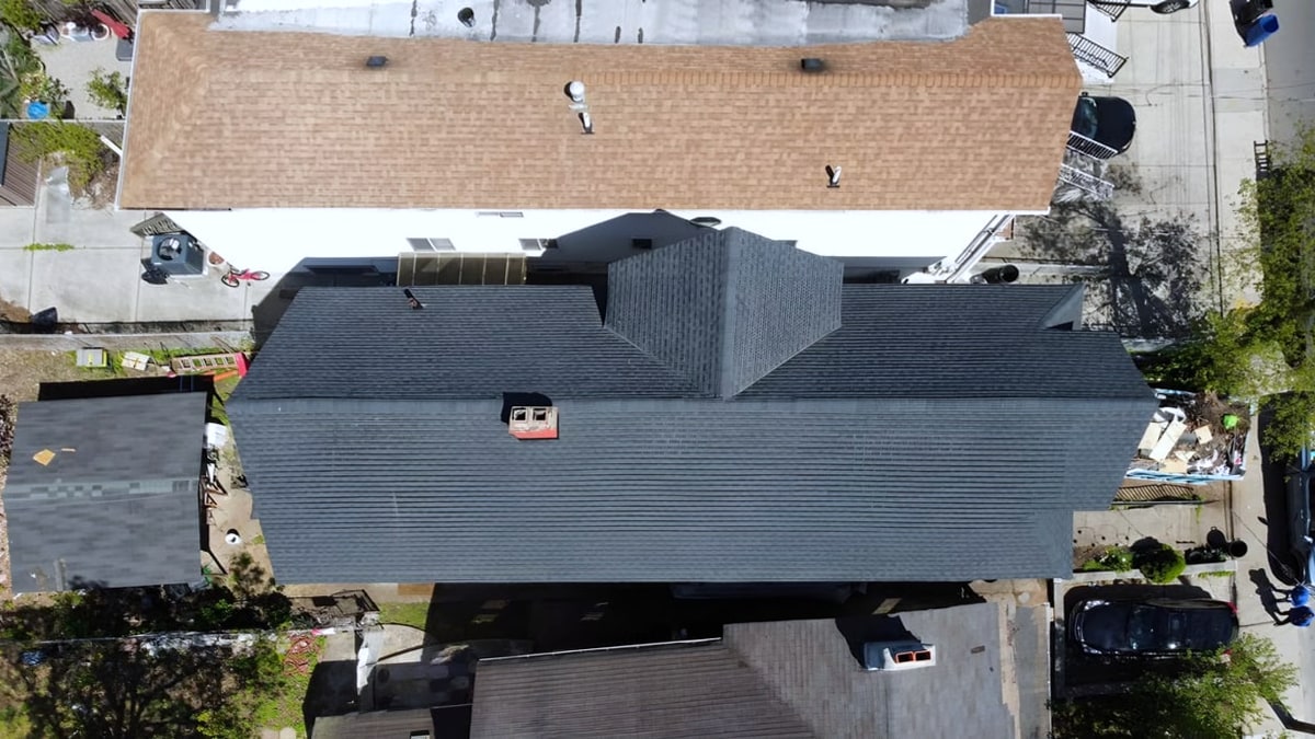 Aerial view of a house with new dark gray shingle roof
